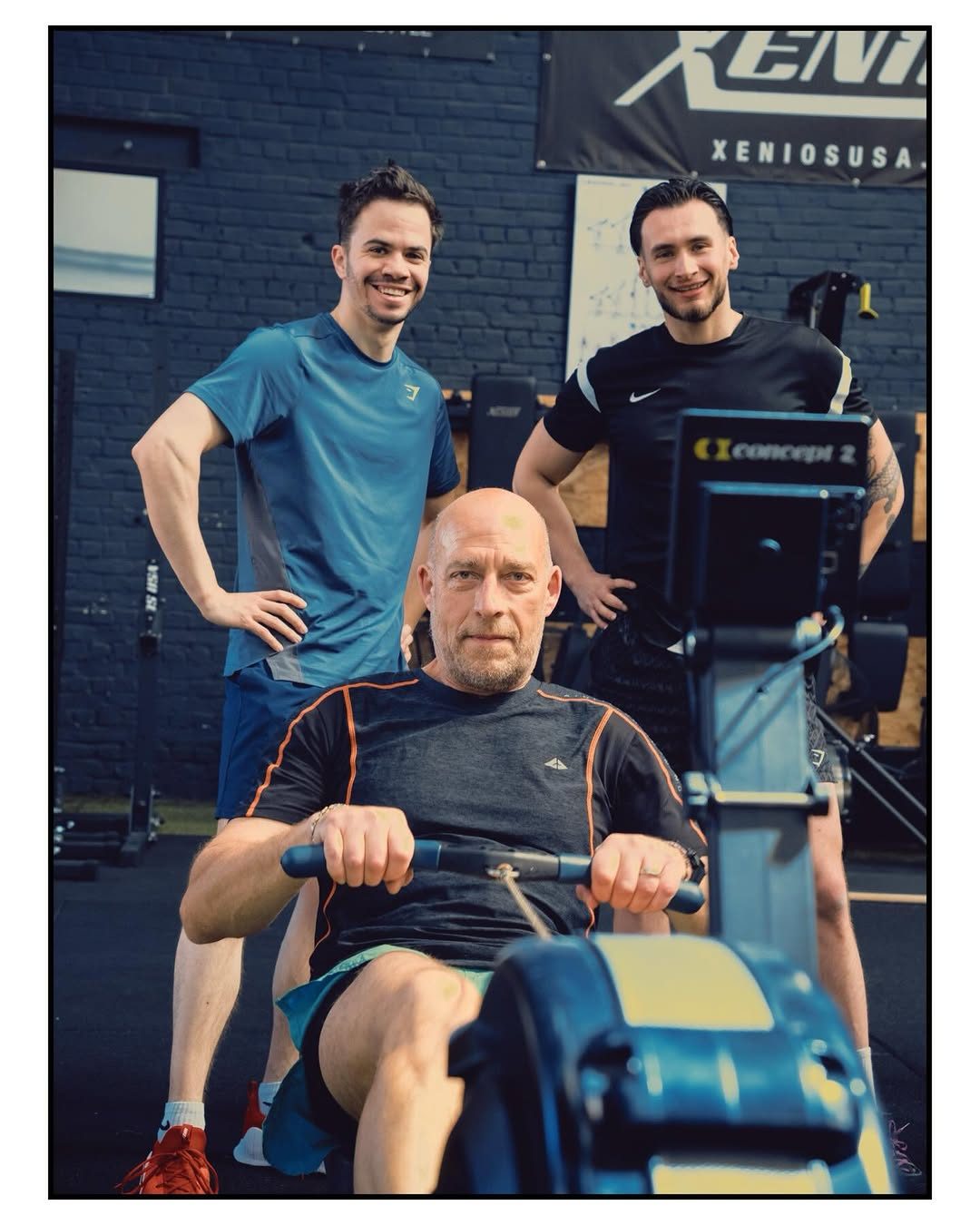 Coaches welcoming an older member training on the rower at the operator's previous gym
